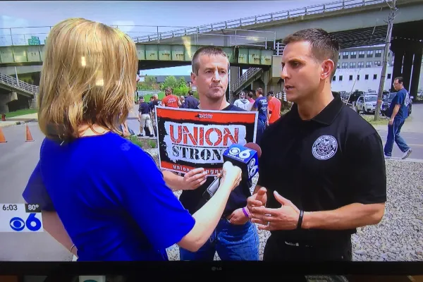 Union members being interviewed by TV reporter