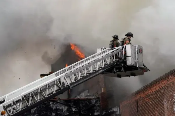 Firefighters on lift fighting smoky fire