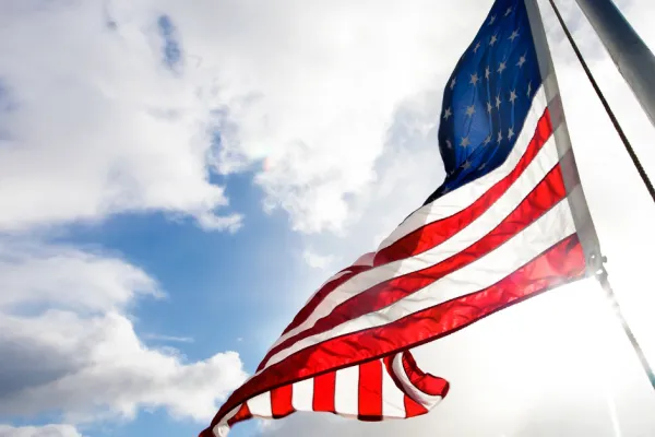 American flag waving in sky photographed from below