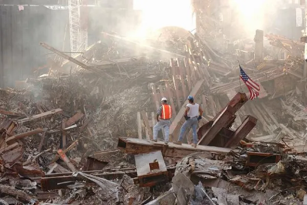 Two people standing on, looking at September 11, 2001 rubble