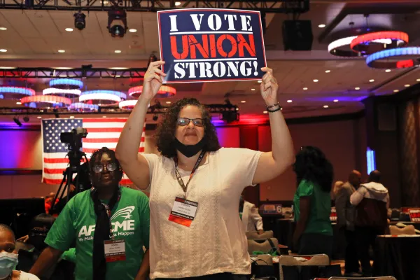 Delegate holding a "I VOTE UNION STRONG" sign at a convention