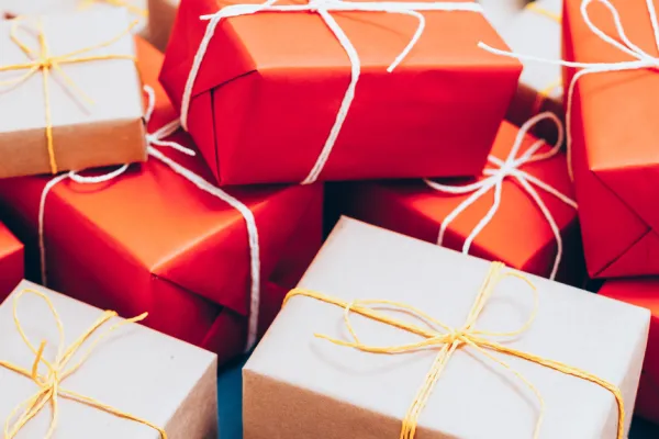 Red and white gifts with yellow ribbon in a pile