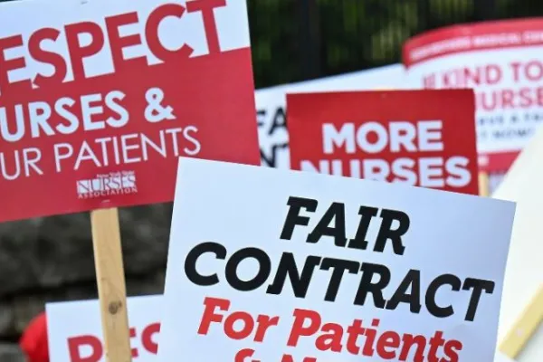 Red and white signs that say "Respect Nurses & Our Patients" and "Fair Contract For Patients"
