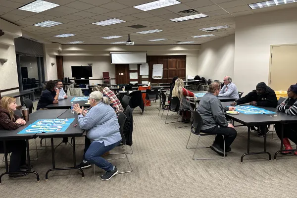 people at square tables participating in training