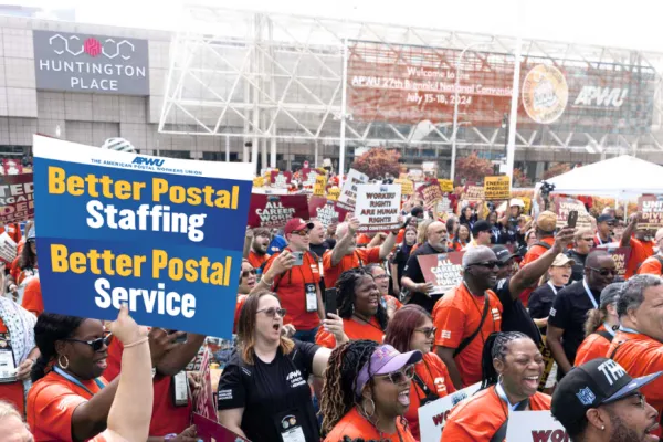 APWU members at a rally with signs advocating for better staffing and a fair contract