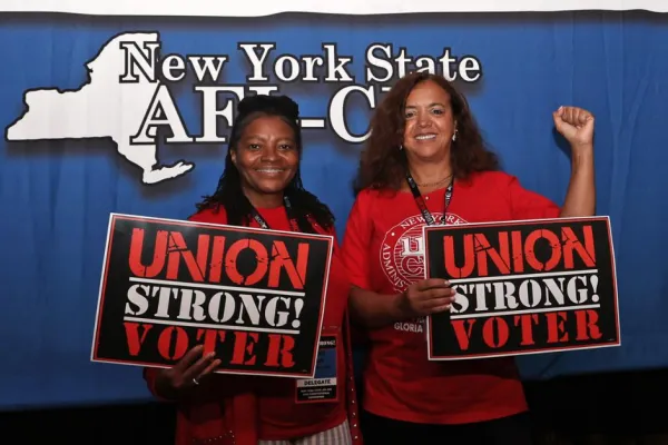 Two union women holding signs that say union strong voter