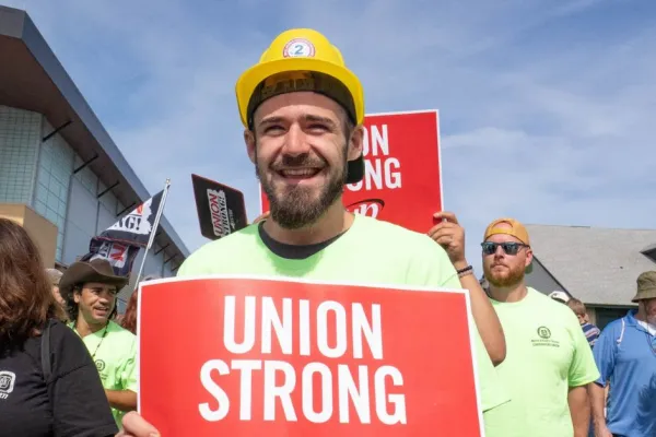 worker holding union strong sign at labor day event