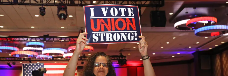 Delegate holding a "I VOTE UNION STRONG" sign at a convention