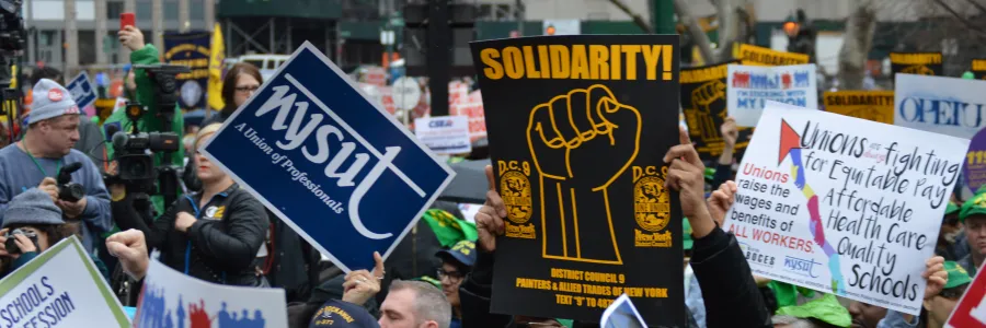 Union members gathered outside holding signs