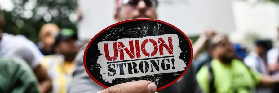 person holding union strong magnet up to camera in a crowd