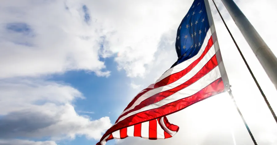 American flag waving in sky photographed from below