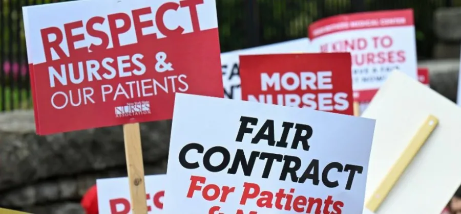 Red and white signs that say "Respect Nurses & Our Patients" and "Fair Contract For Patients"