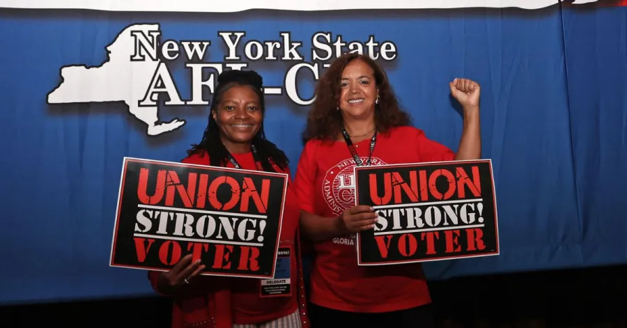 Two union women holding signs that say union strong voter