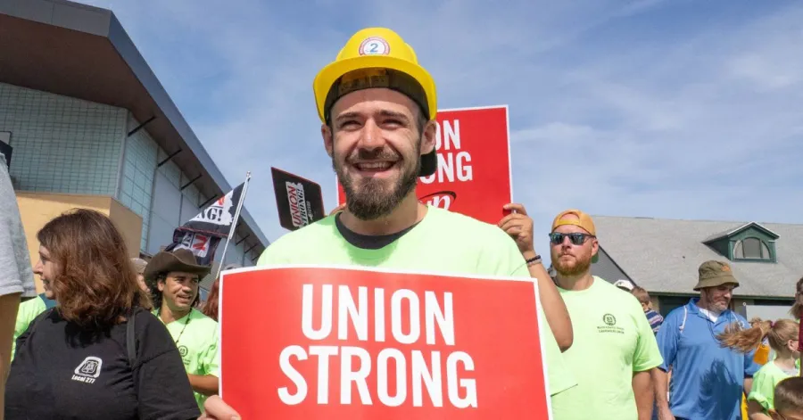 worker holding union strong sign at labor day event
